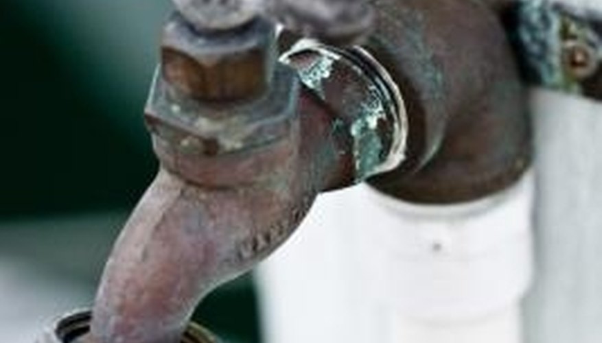 A hose bibb secured to a wooden post. A hose bibb secured to a wooden post.
