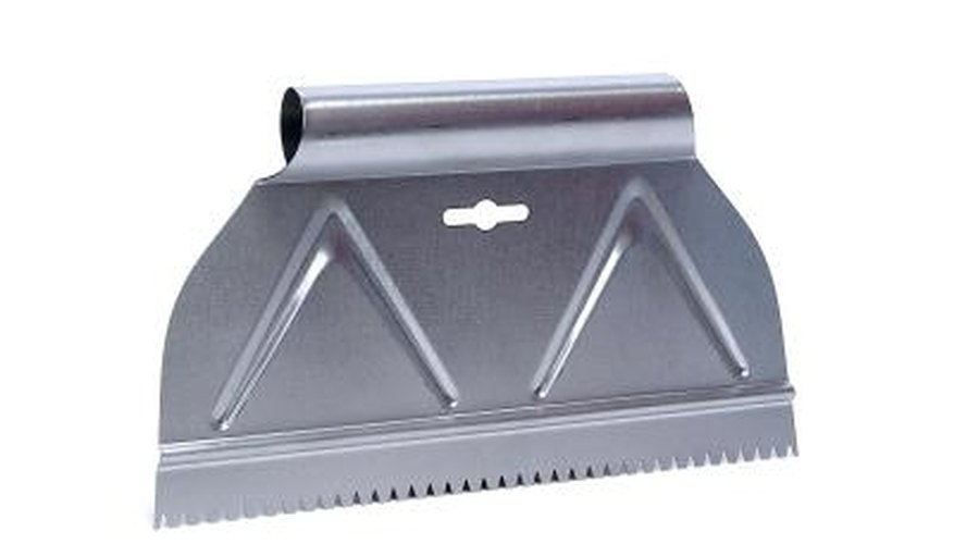 A metal scraper helps lift stuck-on adhesive. A metal scraper helps lift stuck-on adhesive.