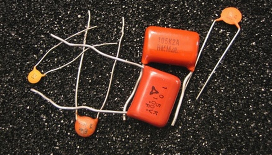 Photo Credit: capacitors image by Albert Lozano from <a href='http://www.fotolia.com'>Fotolia.com</a> Electrical engineers use capacitors to contain electricity.