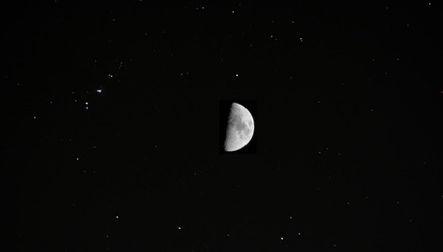 Photo Credit: half moon image by koko300 from <a href='http://www.fotolia.com'>Fotolia.com</a> The moon shares the nighttime sky with background stars.
