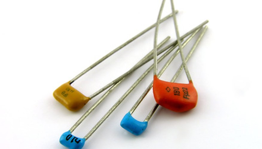 Photo Credit: Capacitors. A close up. It is isolated on a white background. image by Andrey Khritin from <a href='http://www.fotolia.com'>Fotolia.com</a> Capacitors store electricity temporarily.