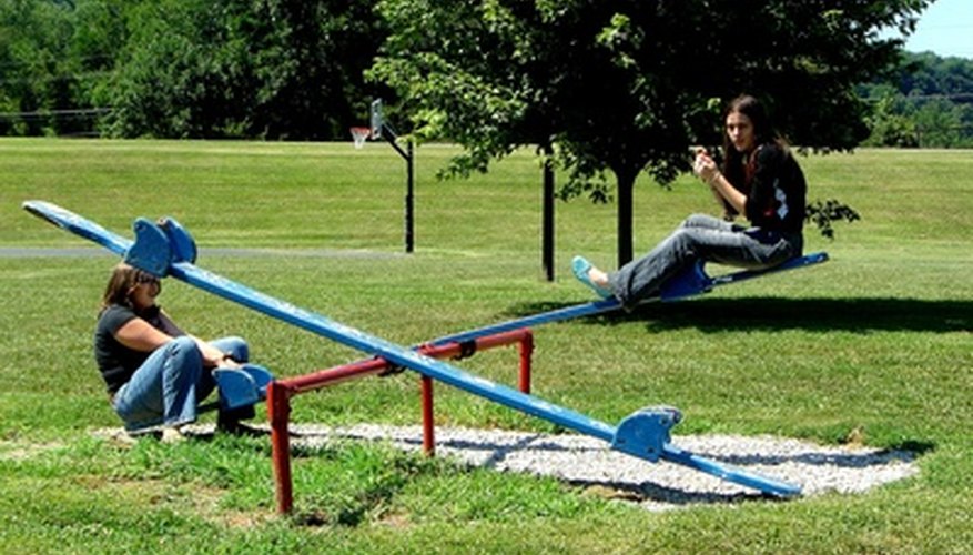 Photo Credit: girls on teeter-totter image by Tammy Mobley from <a href='http://www.fotolia.com'>Fotolia.com</a> Teeter-totters rely on the same principles as catapults.