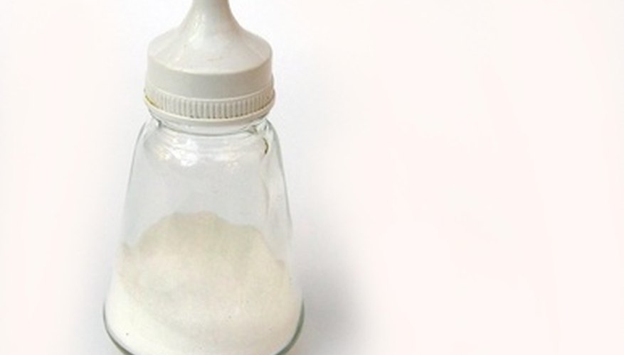Photo Credit: salt cellar image by Edsweb from <a href='http://www.fotolia.com'>Fotolia.com</a> Salt, or sodium chloride, dissolves more readily in water than benzoic acid does.