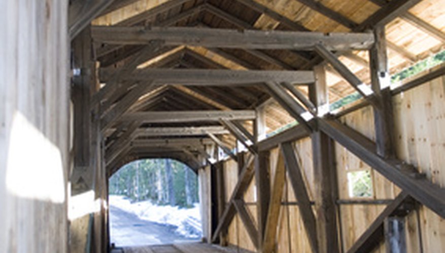 Photo Credit: 'Kissing Bridge' Covered Bridge near Stowe in Vermont image by Rob Hill from <a href='http://www.fotolia.com'>Fotolia.com</a> Calculating the tension and deflection of a rod is important when building structures such as bridges.