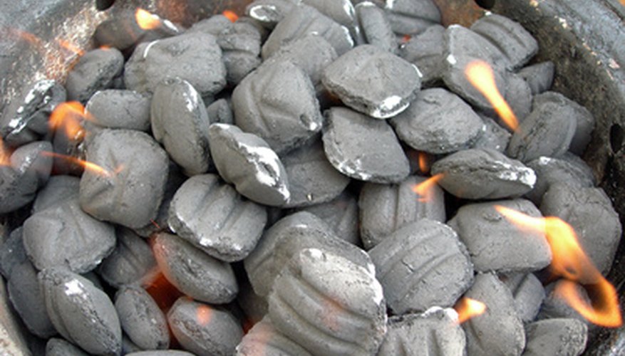 Photo Credit: charcoal on fire image by jedphoto from <a href='http://www.fotolia.com'>Fotolia.com</a> Charcoal briquettes are shaped by using algins from brown seaweed as binders.
