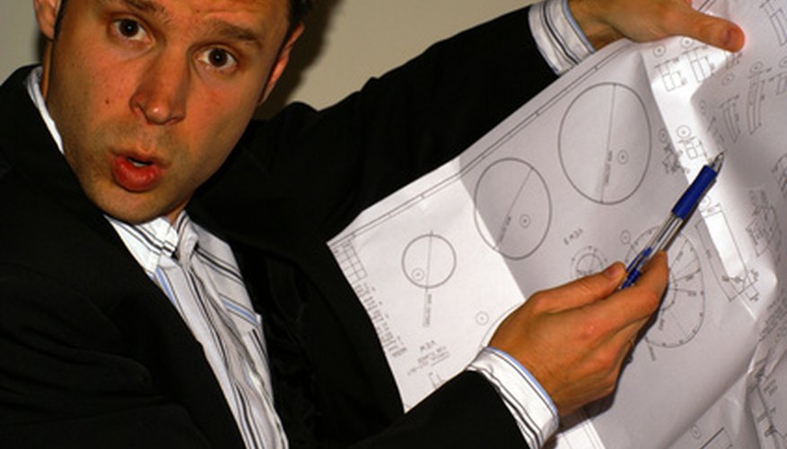 Photo Credit: angry engineer with pencil and mechanical drawing image by Andrei Merkulov from <a href='http://www.fotolia.com'>Fotolia.com</a> A product engineer ensures product functionality.