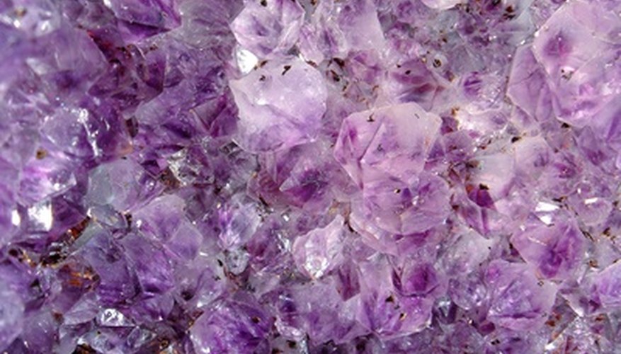 Photo Credit: purple glass image by Tammy Mobley from <a href='http://www.fotolia.com'>Fotolia.com</a> What causes some clear glass to turn purple? Hint: It's not magic.