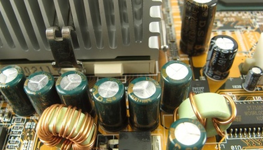 Photo Credit: radiateur de processeur sur carte-mère de type atx image by dead_account from <a href='http://www.fotolia.com'>Fotolia.com</a> Two toroid coils near capacitors.