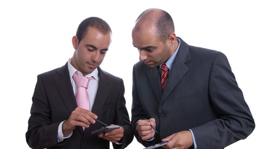 Photo Credit: Two business men holding PDA image by Ricardo Verde Costa from <a href='http://www.fotolia.com'>Fotolia.com</a> Borrower and lender benefit from the agreement.
