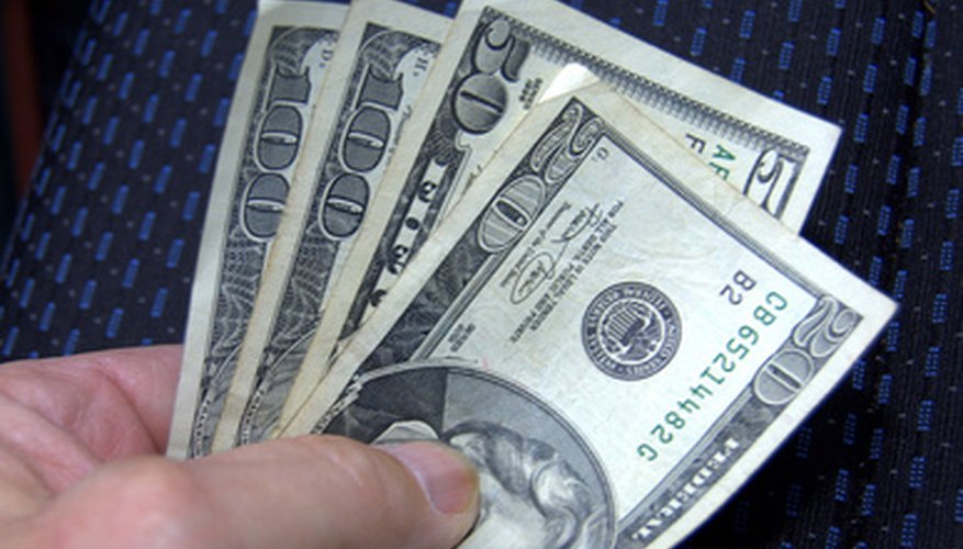 Photo Credit: money in hand image by Bruce MacQueen from <a href='http://www.fotolia.com'>Fotolia.com</a> Consumer surplus measures the buyer's willingness to pay more to acquire the goods.