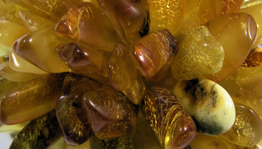 Photo Credit: amber image by Marek Kosmal from <a href='http://www.fotolia.com'>Fotolia.com</a> The color of amber varies because of impurities.