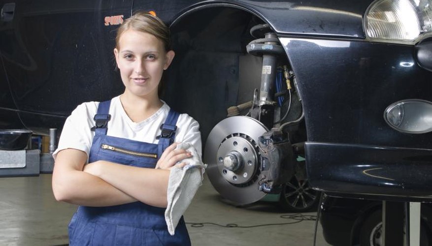 Young female mechanic in training standing garage.