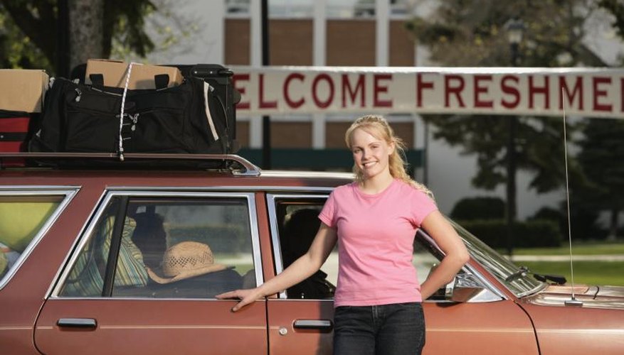 A freshman student arriving with bags on her car at college.