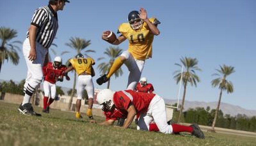Football player jumping over a player.