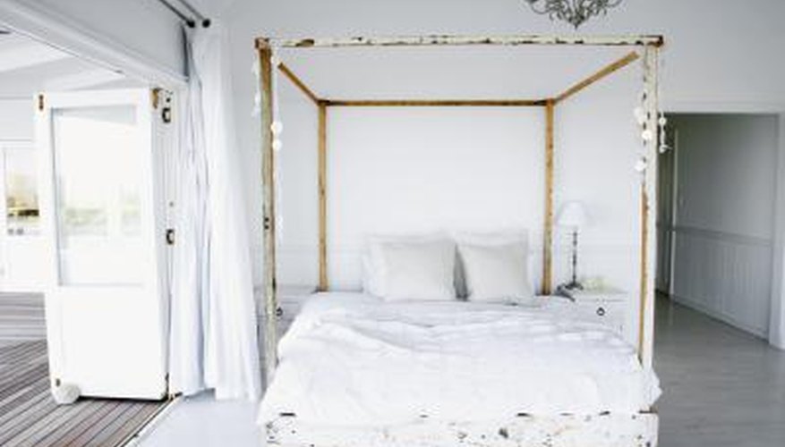 Four poster bed enclosed with white material. Four poster bed enclosed with white material.