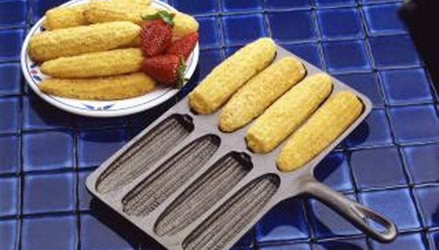 Corn pone is baked in a cast iron molded pan in the oven. Corn pone is baked in a cast iron molded pan in the oven.