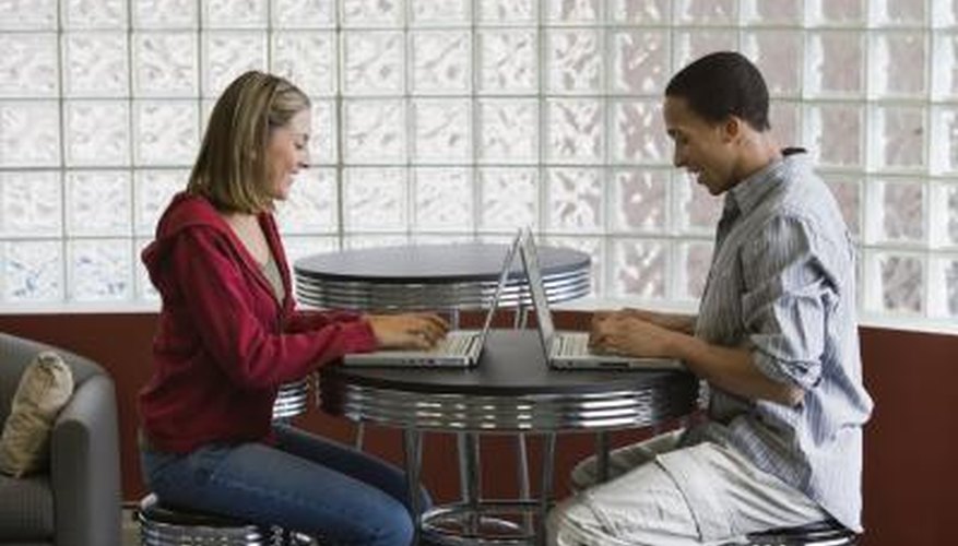 Two young students working on laptops.