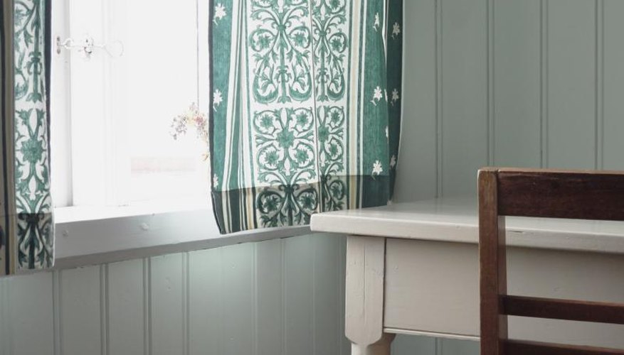 A gauzy bohemian fabric in the window of a beach house. A gauzy bohemian fabric in the window of a beach house.