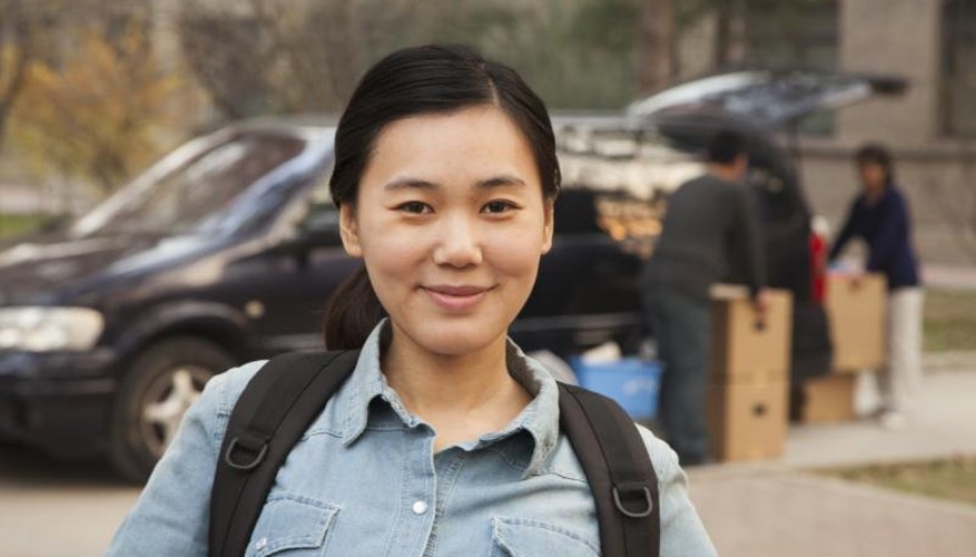 A portrait of a college student and her family unloading moving boxes from a car.