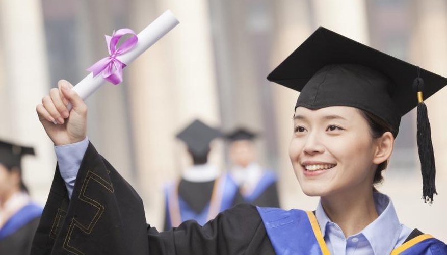 Smiling college graduate holding up diploma.