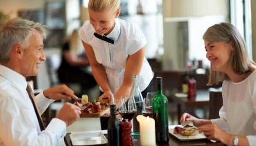 Photo Credit: Jacob Wackerhausen/iStock/Getty Images Waitress attending to customers