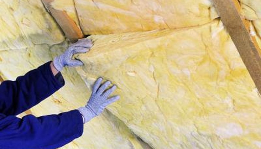 Man installing fiberglass insulation Man installing fiberglass insulation
