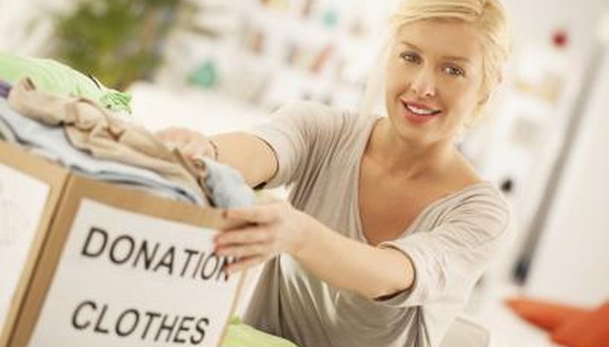A woman packing her donation clothes into a box.