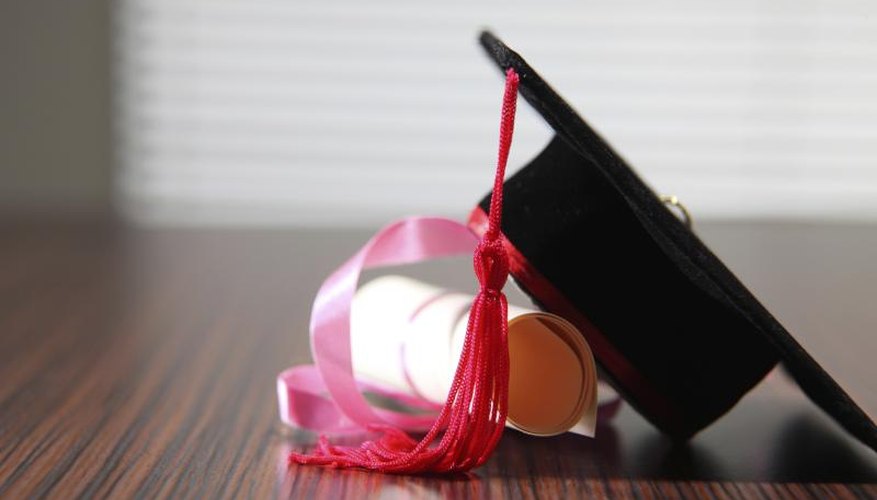 A graduation cap and diploma on a desk.