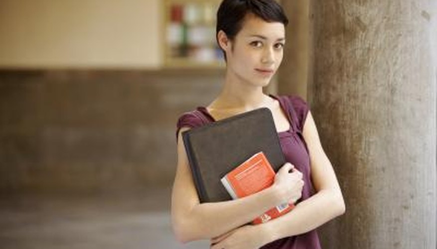 Native American college students holding book in hallway