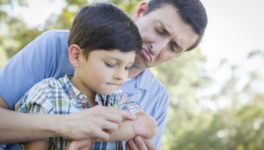 Adult helping child apply bandaid