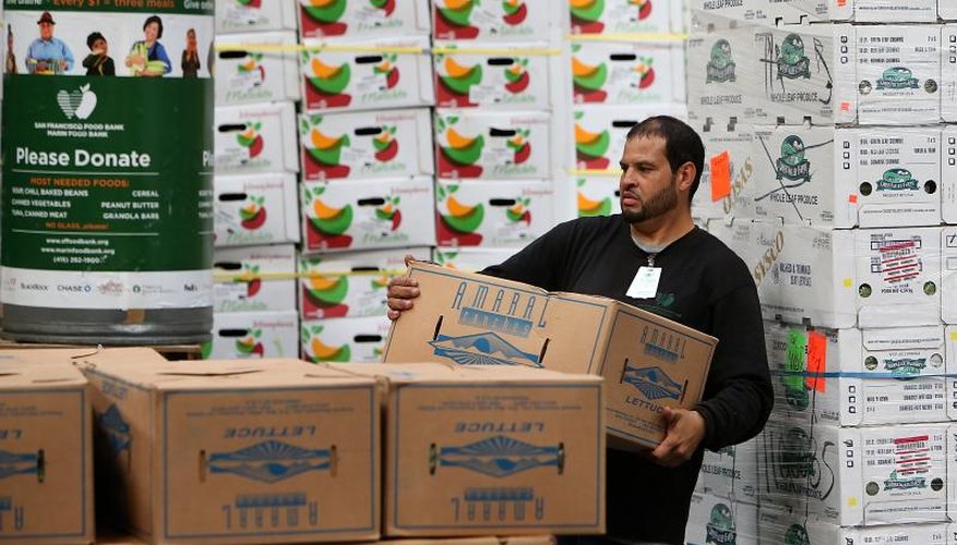 A worker stacks boxes of donated produce.