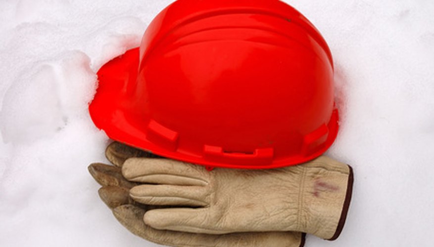 Photo Credit: hardhat and work gloves image by tim elliott from <a href='http://www.fotolia.com'>Fotolia.com</a> Make sure your staff member knows safety regulations and emergency procedures.