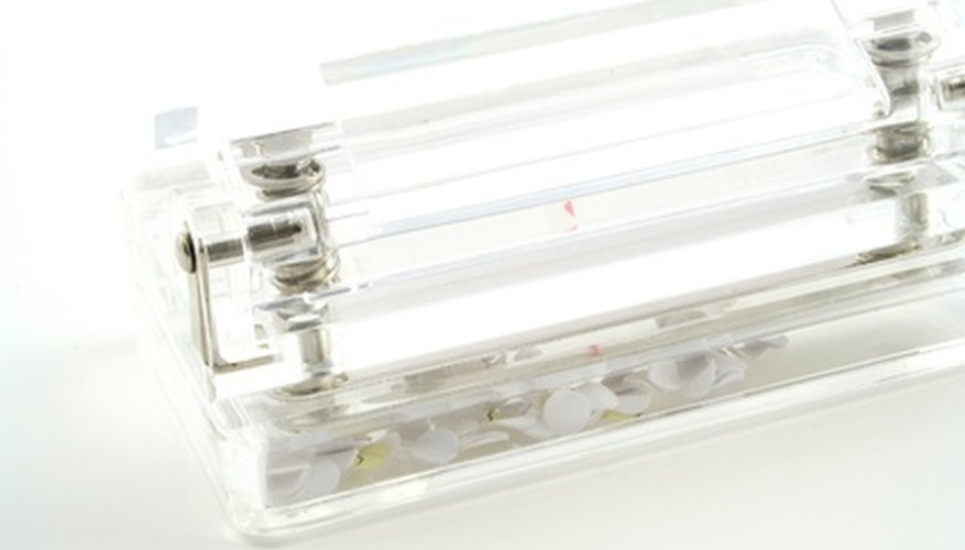 Photo Credit: hole punch image by Christopher Hall from <a href='http://www.fotolia.com'>Fotolia.com</a> Hole punches come in various shapes and sizes.