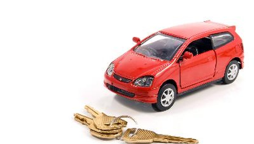 Toy car and keys over white. Rent or buy car concept
