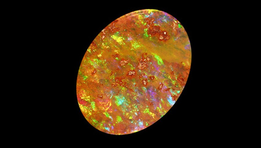 Photo Credit: Precious Mexican Supreme Opal image by Mexgems from <a href='http://www.fotolia.com'>Fotolia.com</a> The sparkle in precious opals like this Mexican fire opal is caused by light bouncing off of crystalline silica structures.