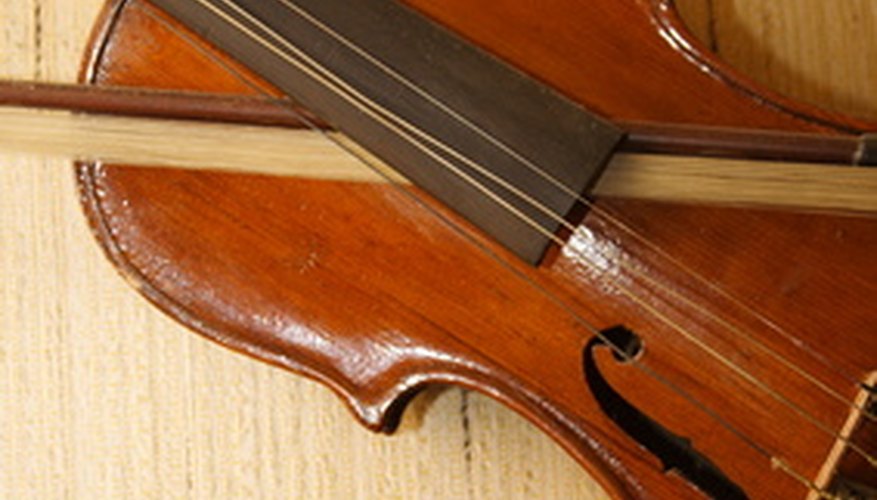 Violín y arco con pelos sueltos, ambos con necesidad de ser reparados.