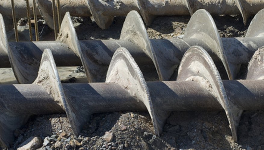 Photo Credit: augers, used to dig deep foundations for a building image by Stephen Gibson from <a href='http://www.fotolia.com'>Fotolia.com</a> Use an auger to drill a cylindrical hole in the ground.