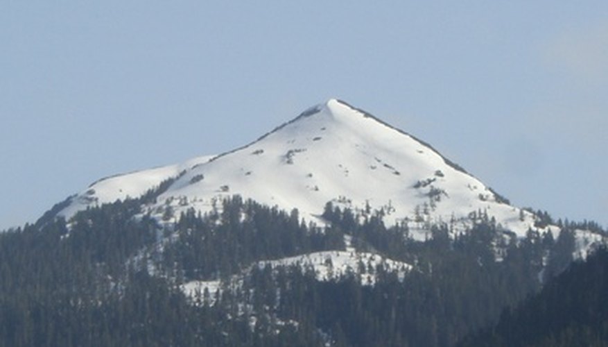 Photo Credit: Mountain image by Click675 from <a href='http://www.fotolia.com'>Fotolia.com</a> Mountains that rise to great heights are often snow covered, reflecting the effects of vertical climate on the higher elevations.