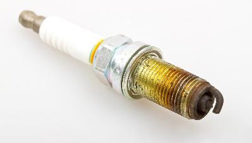 Close-up old burned spark plug on white