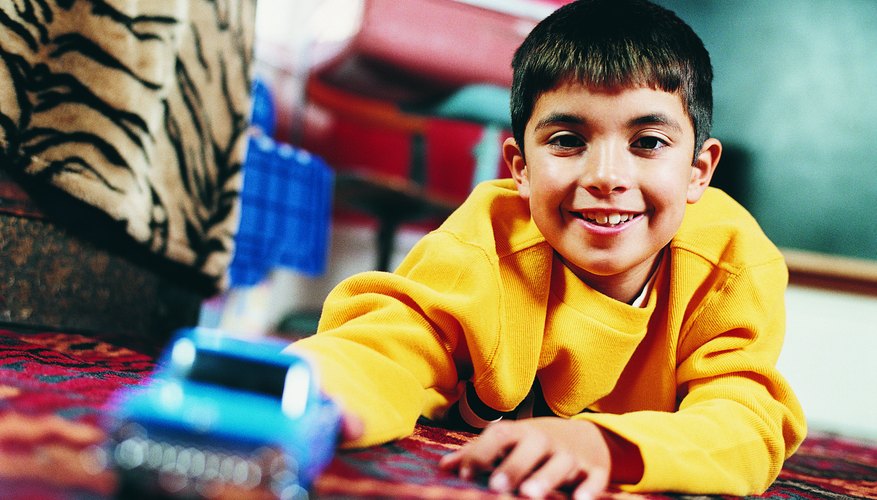 Photo Credit: Digital Vision./Digital Vision/Getty Images This boy uses force to push this toy car.