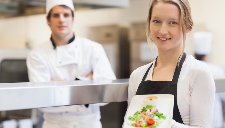 Photo Credit: Wavebreakmedia Ltd/Wavebreak Media/Getty Images Two teens working in a restaurant.