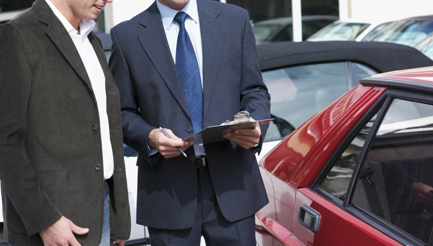 Car salesman talking with customer outdoors