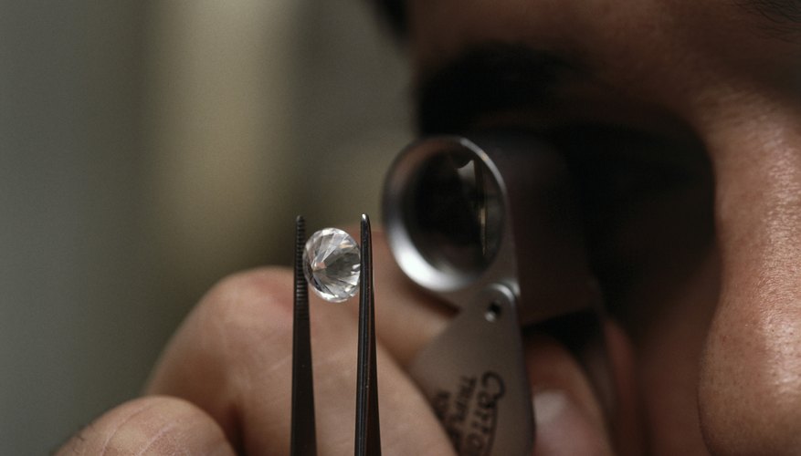 Photo Credit: Ingram Publishing/Ingram Publishing/Getty Images Man looking at diamonds through magnifying glass