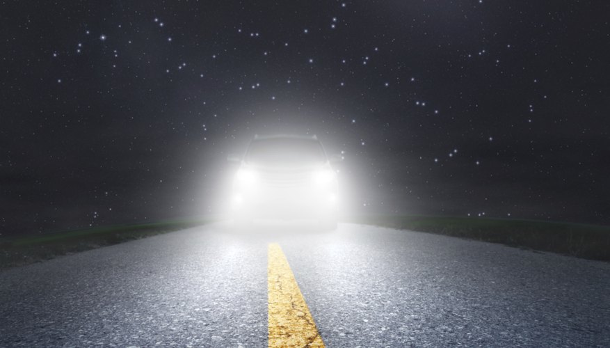 Night driving on an asphalt road towards the headlights