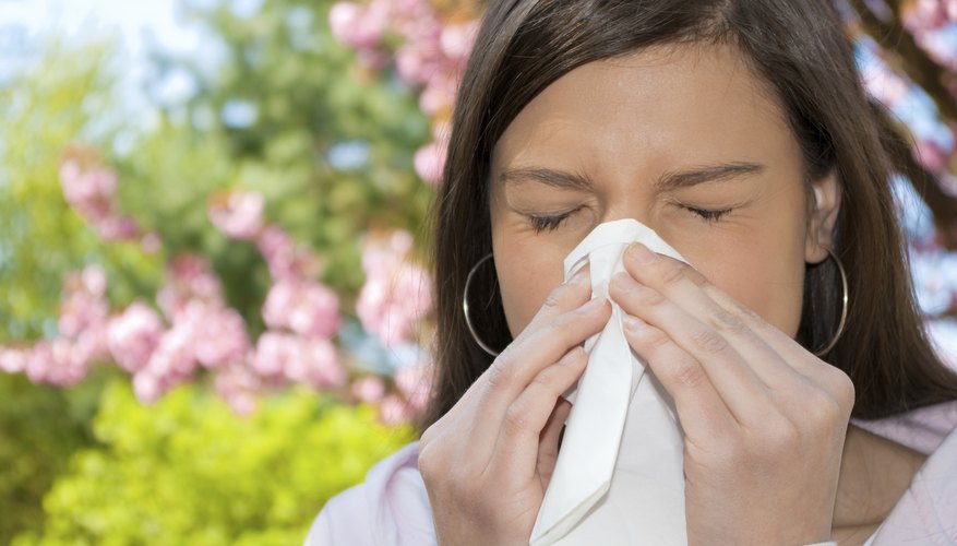 woman sneezing in tissue woman sneezing in tissue