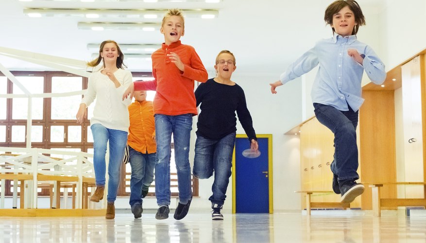 Group of young children running through school hallway Group of young children running through school hallway
