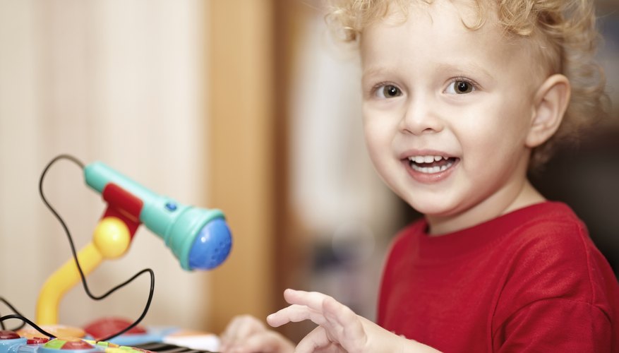 Little boy playing a toy piano with microphone Little boy playing a toy piano with microphone