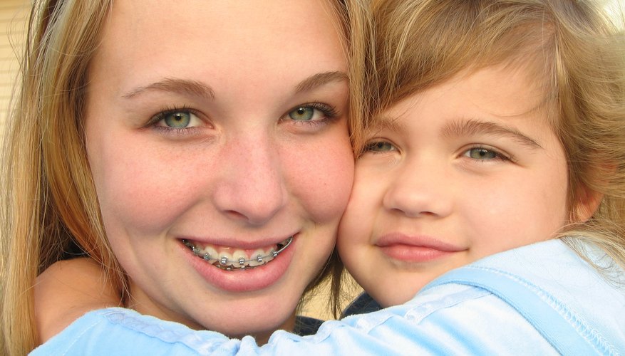 Photo Credit: inkspotts/iStock/Getty Images Teen girl hugging a young child.