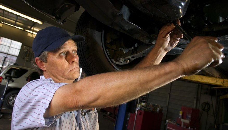 Mechanic under car changing oil