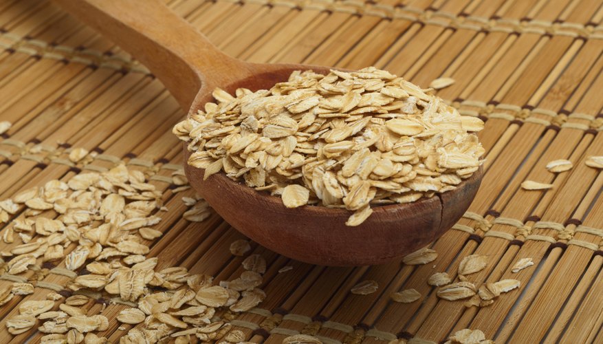 A wooden spoonful of dry oats. A wooden spoonful of dry oats.